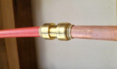 repair made in hot water line using red pex pipe and a sharkbite fitting